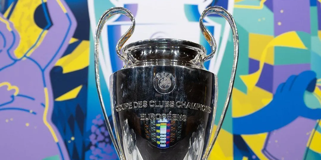 Troféu prateado da UEFA em fundo colorido. A taça mais cobiçada para PSG x Arsenal.