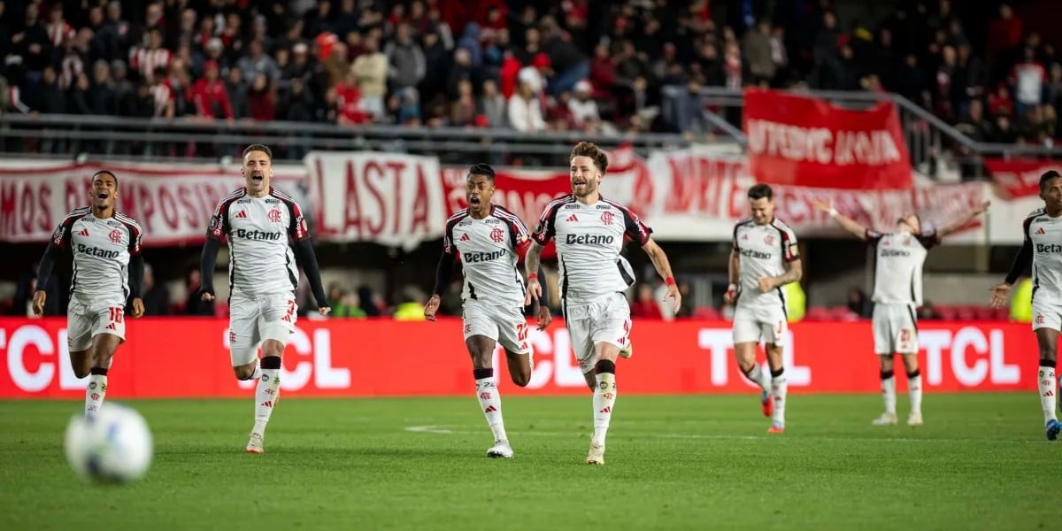 Jogadores do Flamengo comemoram com intensidade durante partida da Copa Libertadores, vestindo o uniforme branco número dois.